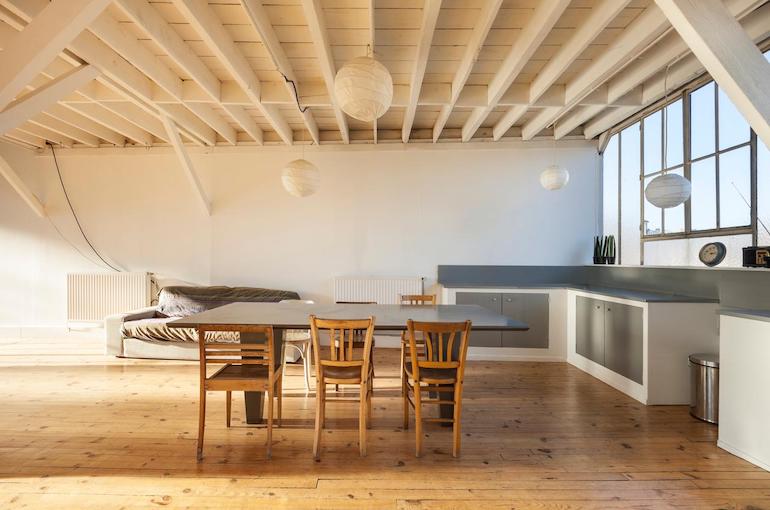 Das moderne weiße Esszimmer einer Eigentumswohnung mit Holzfussboden