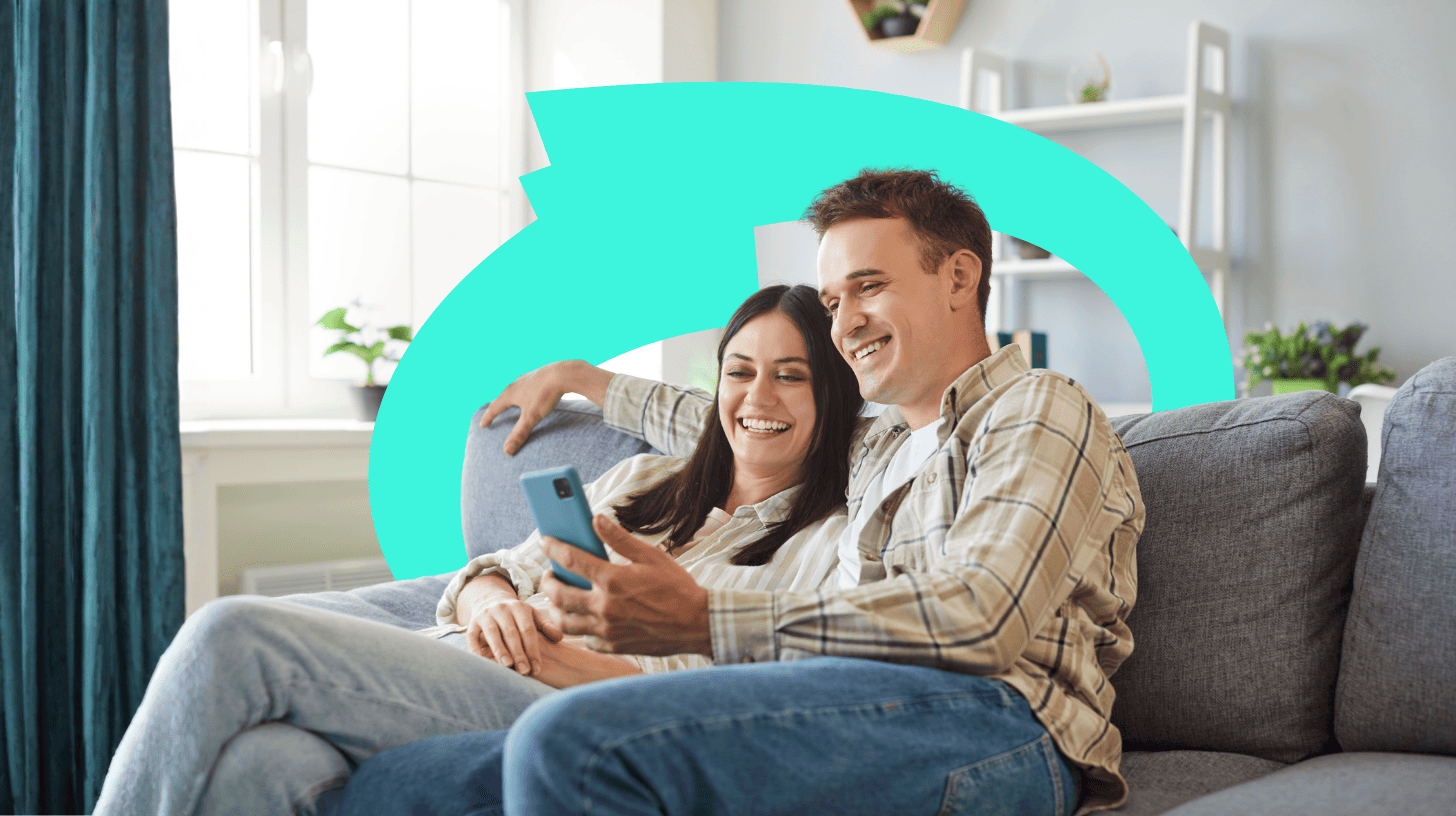 Paar auf der Couch inseriert eine Immobilie