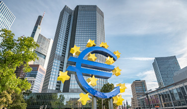 Das EZB-Gebäude, davor das Euro-Symbol in blau mit gelben Sternen drumherum