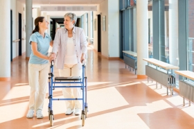 Pflegerin und Seniorin laufen gemeinsam
