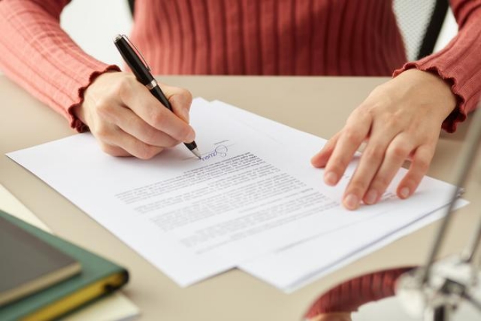 Frau unterschreibt ein Dokument zum Widerspruch der Kündigung