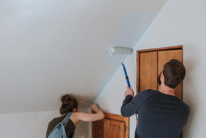 Paar streicht die Dachschräge einer Wohnung