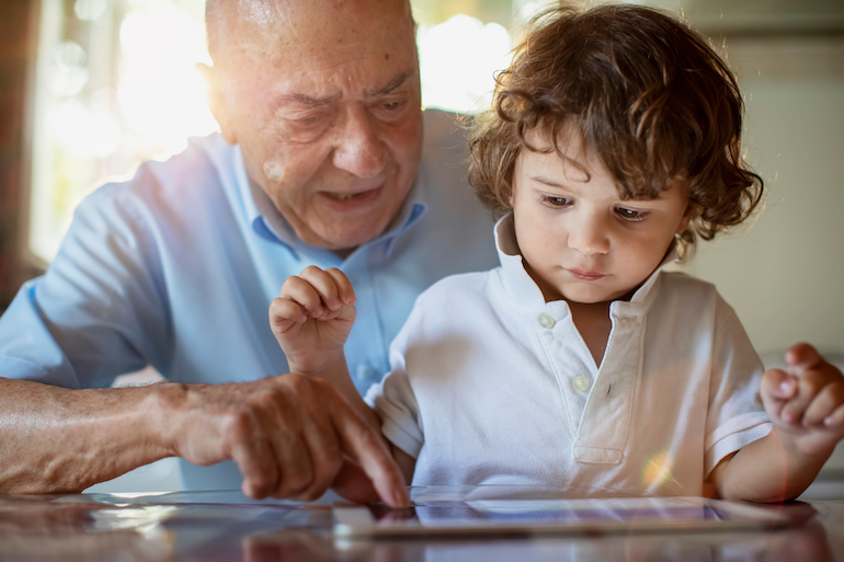 Großvater liest seinem Enkel vor und erklärt