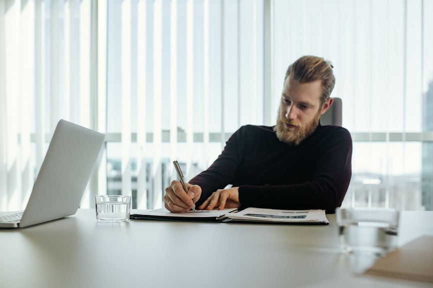 Mann unterschreibt Vertrag in einem Büro